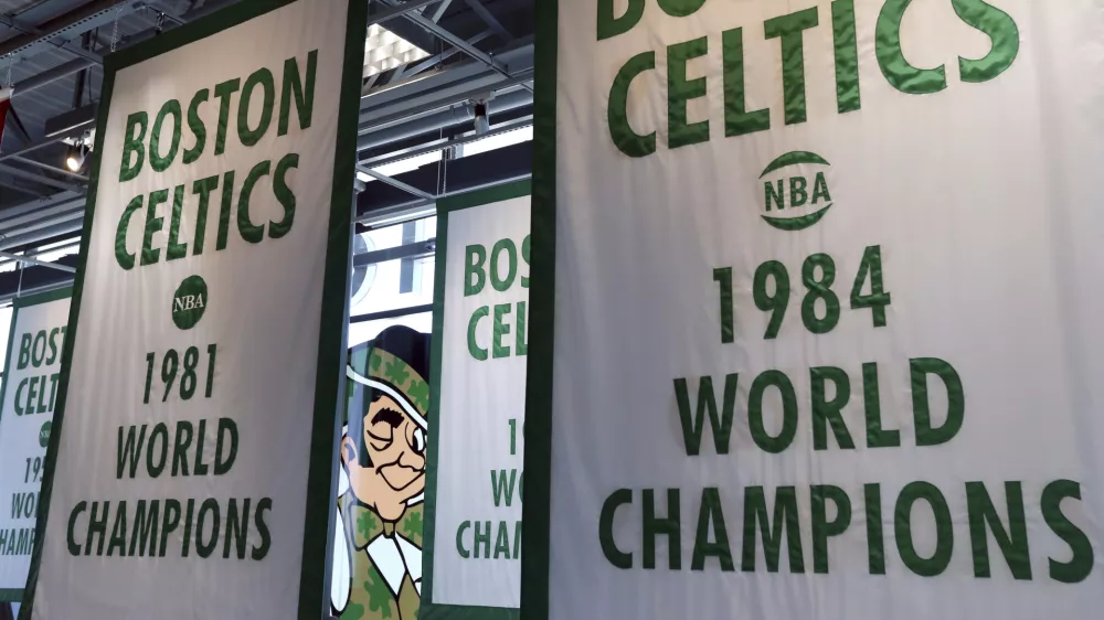 FILE - Lucky the Leprechaun, the Boston Celtics team logo, peers out from in between Celtics championship banners hanging in their new basketball team practice facility, Tuesday, June 19, 2018, in Boston. (AP Photo/Elise Amendola, File)
