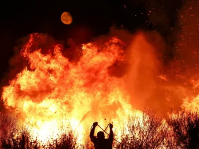 A firefighter works as wildfire continues to burn in Delvina, Albania, August 12, 2025. REUTERS/Florion Goga