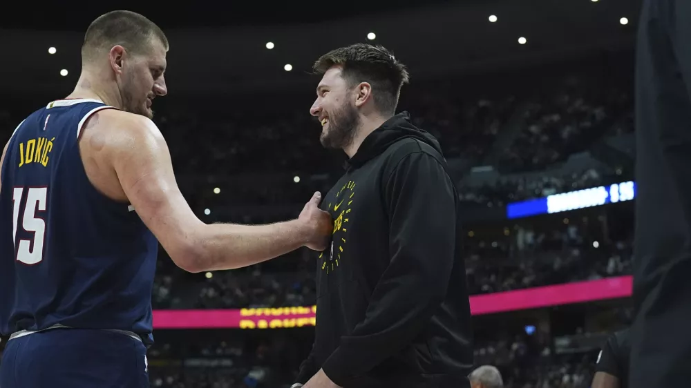 Denver Nuggets center Nikola Jokic, left, greets Los Angeles Lakers guard Luka Doncic, right, in the first half of an NBA basketball game Friday, March 14, 2025, in Denver. (AP Photo/David Zalubowski)