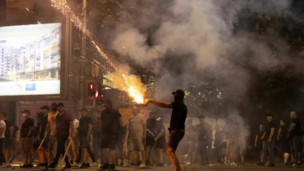 A person fires fireworks, during a standoff between supporters of the ruling party and anti-government protesters in Belgrade, Serbia, August 14, 2025. REUTERS/Djordje Kojadinovic