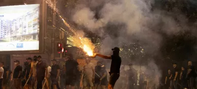 A person fires fireworks, during a standoff between supporters of the ruling party and anti-government protesters in Belgrade, Serbia, August 14, 2025. REUTERS/Djordje Kojadinovic