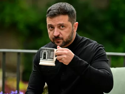 Ukraine's President Volodymyr Zelenskiy drinks from a Downing Street-themed mug as he sits with Britain's Prime Minister Keir Starmer (unseen) in the garden of 10 Downing Street in central London, Britain August 14, 2025. BEN STANSALL/Pool via REUTERS