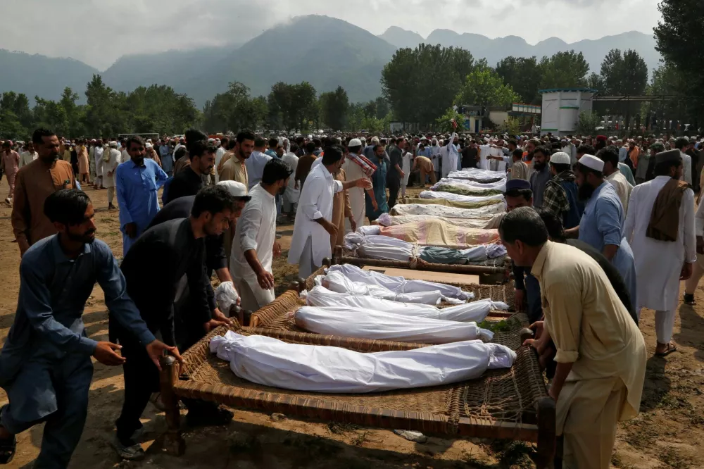 People arrange cots with the bodies of victims as they prepare for their funeral following heavy rain and floods in Buner district in Khyber Pakhtunkhwa province, Pakistan, August 16, 2025. REUTERS/Stringer