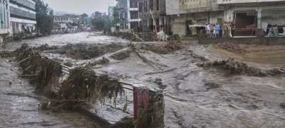 Local residents look at flash flooding due to heavy rains in a neighborhood of Mingora, the main town of Swat Valley, northwestern Pakistan, Friday, Aug. 15, 2025. (AP Photo/Naveed Ali)