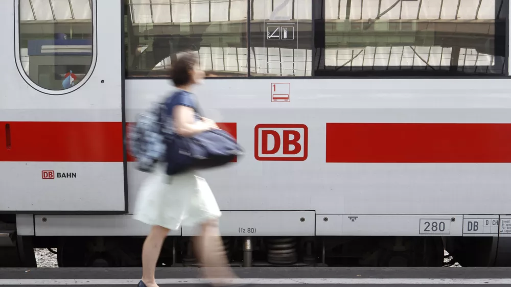 A woman walks past a German railway Deutsche Bahn (DB) train at Zurich main railway station July 9, 2010. Swiss Federal Railways (SBB) and DB signed today a memorandum of understanding to reinforce their cooperation. REUTERS/Arnd Wiegmann (SWITZERLAND - Tags: BUSINESS TRANSPORT TRAVEL)