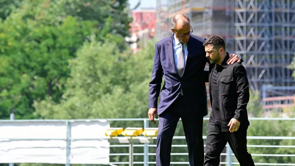 Ukrainian President Volodymyr Zelensky (R) is welcomed by German Chancellor Friedrich Merz upon arrival in the garden of the chancellery in Berlin to join a video conference of European leaders with the US President on the Ukraine war ahead of the summit between the US and Russian leaders, on August 13, 2025. European leaders will hold online talks with US President Donald Trump, hoping to convince him to respect Ukraine's interests when he discusses the war with Putin in Alaska on Friday.   JOHN MACDOUGALL/Pool via REUTERS