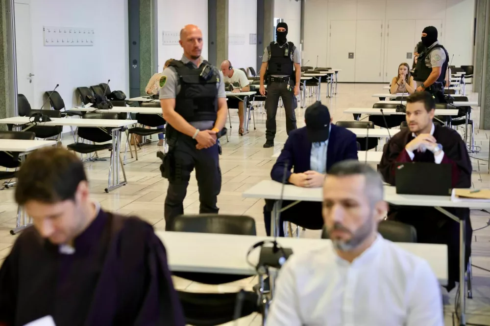 Sojenje poteka ob prisotnosti policije in pripadnikov posebne enote. V ospredju obtoženi Roland Cretu. 