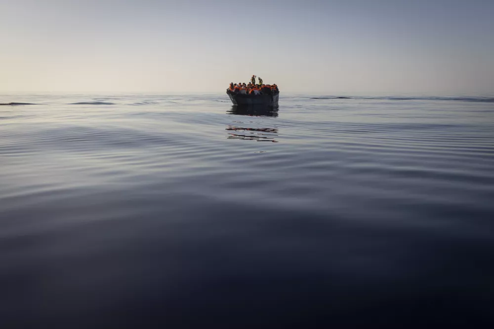 FILE - Migrants with life jackets provided by volunteers of the Ocean Viking, a migrant search and rescue ship run by NGOs SOS Mediterranee and the International Federation of Red Cross (IFCR), still sail in a wooden boat as they are being rescued, on Aug. 27, 2022. The border and coast guard agency Frontex estimated that more than 50,300 attempts were made to enter the EU without authorization from January to May. It's more than double the number in the same period last year, and the most since 2017. (AP Photo/Jeremias Gonzalez, File)
