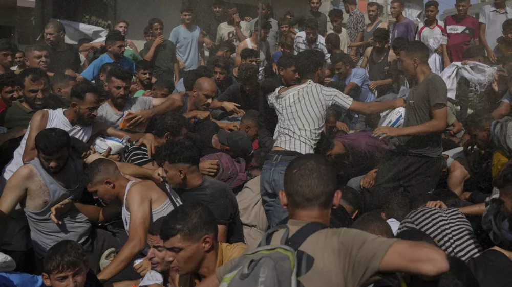 Palestinians struggle to collect humanitarian aid airdropped into Gaza City, northern Gaza Strip, Thursday, Aug. 14, 2025. (AP Photo/Jehad Alshrafi)
