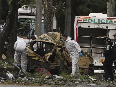 Forensics inspect the site of a bomb explosion outside an Air Force base in Cali, Colombia, Thursday, Aug. 21, 2025. (AP Photo/Santiago Saldarriaga)