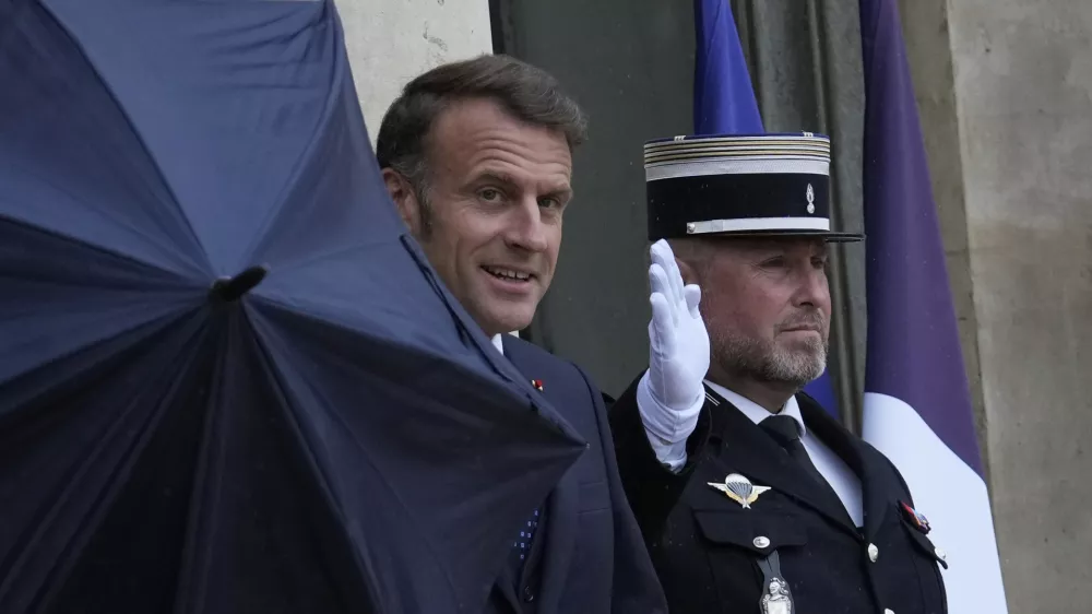 French President Emmanuel Macron uses an umbrella as he waits for Lebanese Prime Minister Nawaf Salam Thursday, July 24, 2025 at the Elysee Palace in Paris. (AP Photo/Michel Euler)
