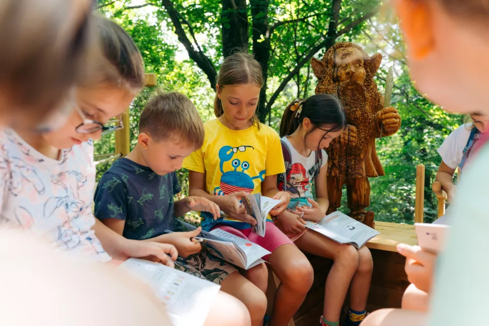 Gozdna dogodivščina je prava pesniška preizkušnja, pustolovske škratolovce na njej čaka kovanje zlatih verzov, zbiranje zlatnikov in pečatov, na cilju pa zaslužena nagrada. F Arhiv Škrateljc