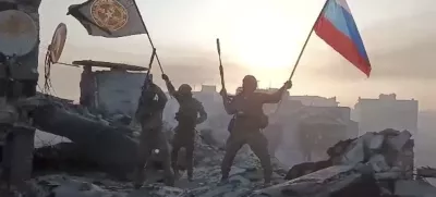 Wagner mercenary group fighters wave flags of Russia and Wagner group on the top of a building in an unidentified location in the course of Russia-Ukraine conflict, in this still image taken from video released on May 20, 2023, along with a statement by Russian mercenary chief Yevgeny Prigozhin about taking full control of the Ukrainian city of Bakhmut. Press service of "Concord"/Handout via REUTERS ATTENTION EDITORS - THIS IMAGE WAS PROVIDED BY A THIRD PARTY. NO RESALES. NO ARCHIVES. MANDATORY CREDIT.