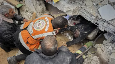 FILE - EDS NOTE: GRAPHIC CONTENT - Rescue workers and volunteers attempt to pull the body of a man from the rubble following an Israeli army airstrike in Khan Younis, southern Gaza Strip, Thursday, March 20, 2025. (AP Photo/Mariam Dagga, File)