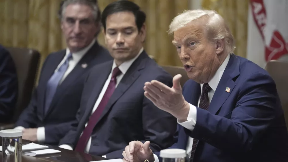 President Donald Trump speaks during a cabinet meeting, Tuesday, Aug. 26, 2025, at the White House in Washington, as from left, Secretary of Interior Doug Burgum and Secretary of State Marco Rubio, look on. (AP Photo/Mark Schiefelbein)