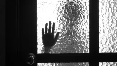 Photo of person standing over the door and its hand on the glass near the handle / Foto: Vitalii Petrushenko