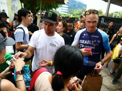 FILE PHOTO: Cycling - Tour de France Singapore Criterium - Media Day - Singapore - November 9, 2024 Astana Qazaqstan Team's Mark Cavendish with Team TDF Legends' Chris Froome as they distribute ice creams to fans during the media day REUTERS/Edgar Su/File Photo