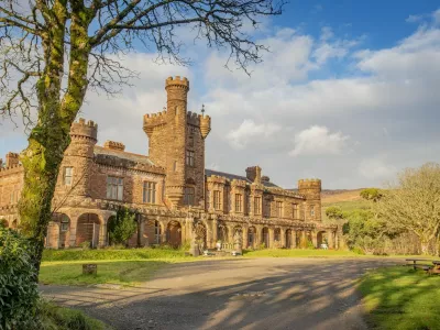 Kinloch Castle. See SWNS story SWOCcastle. July 29, 2021.One of Prince Charles' favourite castles is looking for a new owner to save it from ruin as the iconic landmark crumbles in need of repair. Kinloch Castle on the Island of Rum in Scotland is on the market for a new owner who could put the money required into fixing up the crumbling castle. With a nominal value of just £1, this is an extremely rare opportunity to take ownership of a 120-year-old castle that Prince Charles himself has been passionate about saving. Repairs on the crumbling turreted red-sandstone house are estimated at an eye-watering £20 million to restore the castle to it's former glory. A private individual or a charity, foundation or private company who can provide such an amount for the castle repairs are in with a chance of owning the incredible house. Any new hopeful owners will have to prove that they have the resources to save this Category A landmark and show plans for bettering the future of the small isle where the castle sits.,Image: 624152990, License: Rights-managed, Restrictions: This image is not available for use at a stock rate unless with prior agreement. This image hereby disclosed to your organisation is so disclosed on the condition that your organisation will take all steps necessary to ensure that any identifiable personal data is processed in full compliance with the Data Protection Act 2018follow us on twitter - @swnsbrowse our website - swns.comemail pix@swns.com, Model Release: no