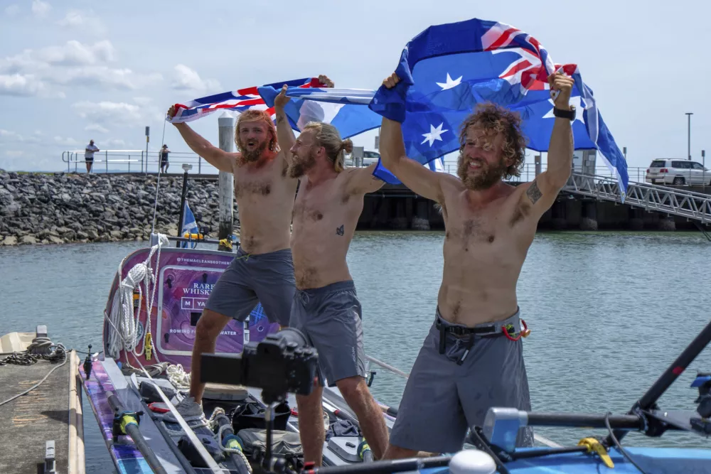 Scottish brothers, Ewan, Jamie and Lachlan, Maclean react after completing their record breaking row from Peru across the Pacific Ocean to Cairns, Australia, Saturday, Aug. 30, 2025. (Nuno Avendano/AAP Image via AP)