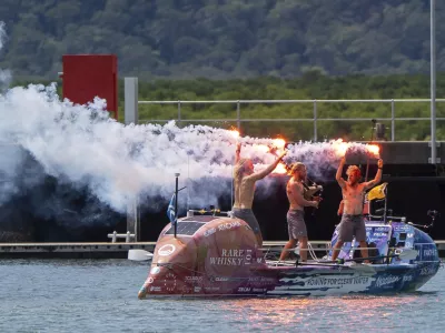 Scottish brothers, Ewan, Jamie and Lachlan, Maclean react after completing their record breaking row from Peru across the Pacific Ocean to Cairns, Australia, Saturday, Aug. 30, 2025. (Nuno Avendano/AAP Image via AP)