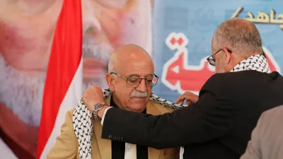 FILE PHOTO: Representative of Hamas in Yemen, Muadh Abu Shammalah, gives the head of Houthi-led government Ahmad al-Rahawi a Palestinian keffiyeh during his visit to the Hamas office in Sanaa, Yemen August 19, 2024. REUTERS/Khaled Abdullah/File Photo
