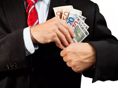 Businessman putting money (euro banknotes) in his pocket. / Foto: Ellobo1
