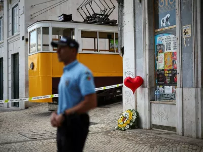 A wreath of flowers lies on the ground next to a balloon near the site of the accident after Gloria funicular railway car, a popular tourist attraction, derailed and crashed, resulting in multiple casualties, according to authorities, in Lisbon, Portugal, September 4, 2025. REUTERS/Pedro Nunes