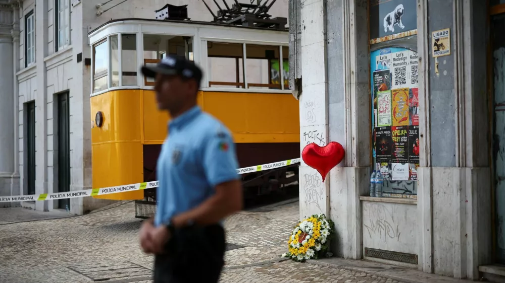 A wreath of flowers lies on the ground next to a balloon near the site of the accident after Gloria funicular railway car, a popular tourist attraction, derailed and crashed, resulting in multiple casualties, according to authorities, in Lisbon, Portugal, September 4, 2025. REUTERS/Pedro Nunes