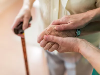 Nurse consoling her elderly patient by holding her hands / Foto: Piksel