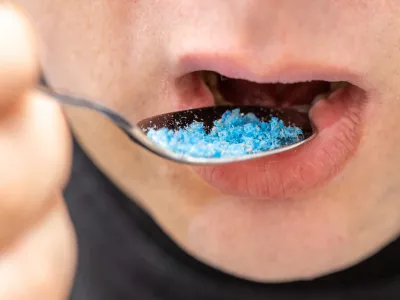 Microplastic in food, Environment and health concept, Person putting a spoon with plastic particles in his mouth