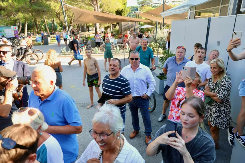 Skupina radovednežev, ki se je zbrala pred vilo tartini, v kateri se je poročil Golob