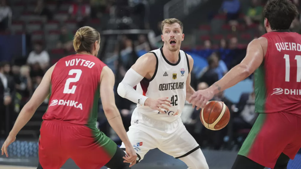 Germany's Andreas Obst, centre, in action during the Eurobasket, European Basketball Championship round of 16 match between Germany and Portugal at the Riga Arena in Riga, Latvia, Saturday, Sept. 6, 2025. (AP Photo/Sergei Grits)