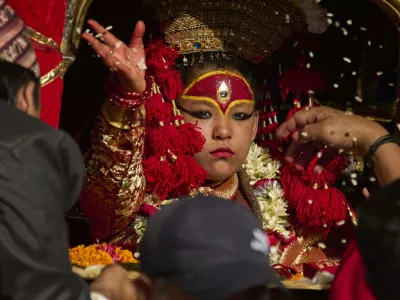 Living goddess Kumari sprinkles beaten rice while performing rituals before her chariot is being pulled during Indra Jatra, a festival that marks the end of the rainy season in Kathmandu, Nepal, Saturday, Sept. 6, 2025. (AP Photo/Niranjan Shrestha)