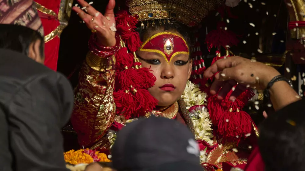 Living goddess Kumari sprinkles beaten rice while performing rituals before her chariot is being pulled during Indra Jatra, a festival that marks the end of the rainy season in Kathmandu, Nepal, Saturday, Sept. 6, 2025. (AP Photo/Niranjan Shrestha)