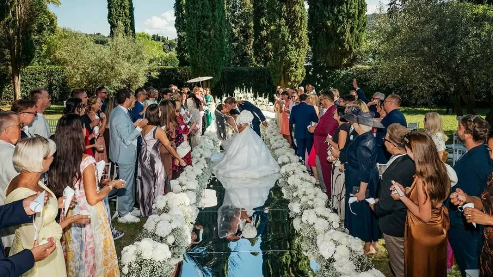 Prva slika s poroke para Golob Gaber, ki je obšla Slovenijo. Na žalost je posneta tako, da se praktično ne vidi nikogar, razen mediteranskega rastja. Mož in žena je pripisal urednik premierovega profila. 
