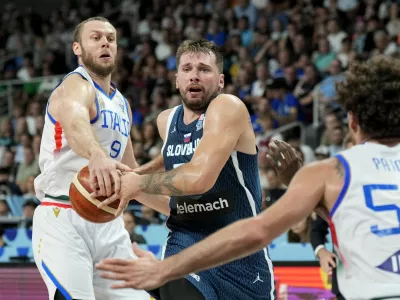 Basketball - FIBA EuroBasket 2025 - Round of 16 - Italy v Slovenia - Xiaomi Arena, Riga, Latvia - September 7, 2025 Italy's Nicolo Mell in action with Slovenia's Luka Doncic REUTERS/Ints Kalnins