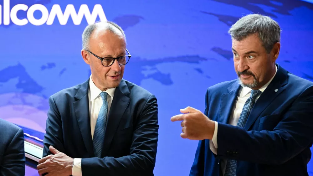 Bavarian State Premier Markus Soeder gestures next to German Chancellor Friedrich Merz as they tour the IAA Mobility 2025 auto show in Munich, Germany, September 9, 2025. REUTERS/Angelika Warmuth