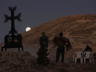 People watch as the moon shines during a total lunar eclipse over Kfardebian village, northeast of Beirut, Lebanon, Sunday, Sept. 7, 2025. (AP Photo/Bilal Hussein) / Foto: Bilal Hussein