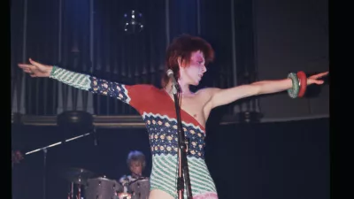 Bowie, ki nastopa kot Ziggy Stardust v asimetrični kombinezonu, ki ga je oblikoval Kansai Yamamoto. F V&A Collections 