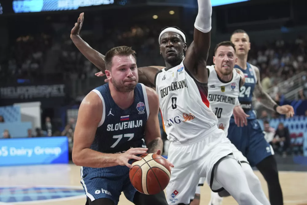 Slovenia's Luka Doncic, left, and Germany's Isaac Bonga during the Eurobasket, European Basketball Championship quarter final match between Germany and Slovenia at the Riga Arena in Riga, Latvia, Wednesday, Sept. 10, 2025. (AP Photo/Sergei Grits)