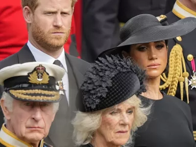 Britain's King Charles III, from bottom left, Camilla, the Queen Consort, Prince Harry and Meghan, Duchess of Sussex watch as the coffin of Queen Elizabeth II is placed into the hearse following the state funeral service in Westminster Abbey in central London Monday Sept. 19, 2022. The Queen, who died aged 96 on Sept. 8, will be buried at Windsor alongside her late husband, Prince Philip, who died last year. (AP Photo/Martin Meissner, Pool)