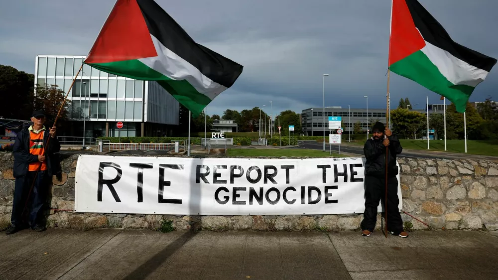 Pro-Palestinian protestors hold flags and a sign outside the RTE (Radio Telefis Eireann) Irish public service broadcaster television studios, in Dublin, Ireland, September 11, 2025. REUTERS/Clodagh Kilcoyne