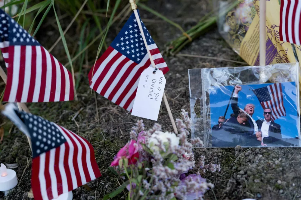 FILE PHOTO: An image of U.S. President Donald Trump taken after an attempted assassination at a political rally near Butler, Pennsylvania, is placed at a makeshift memorial for U.S. right-wing activist, commentator, Charlie Kirk, an ally of U.S. President Donald Trump, who was fatally shot during an event at Utah Valley University, outside of Timpanogos Regional Hospital, in Orem, Utah, U.S. September 11, 2025. REUTERS/Cheney Orr?    TPX IMAGES OF THE DAY/File Photo