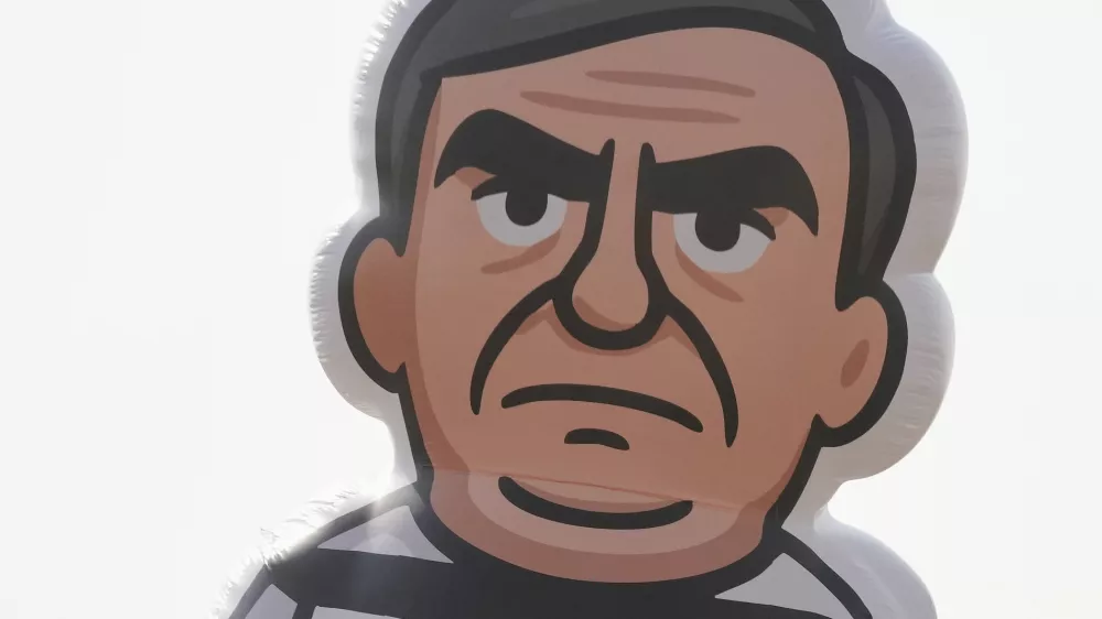 University students display an inflatable doll of Brazil's former President Jair Bolsonaro wearing prisoner garb in Brasilia, Brazil, Friday, Sept. 12, 2025, the morning after the Supreme Court convicted and sentenced him to prison for attempting a coup to remain in office despite his 2022 electoral defeat. (AP Photo/Eraldo Peres)