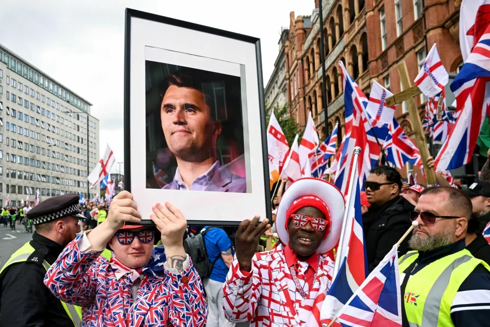 Protesters hold a picture of U.S. conservative activist Charlie Kirk, who was fatally shot while speaking at an event at Utah Valley University, on the day of an anti-immigration rally organised by British anti-immigration activist Stephen Yaxley-Lennon, also known as Tommy Robinson, in London, Britain, September 13, 2025. REUTERS/Jaimi Joy