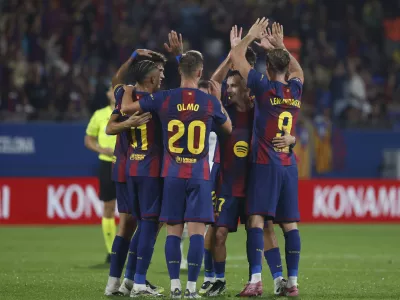 Barcelona's Robert Lewandowski, right, is congratulated after the VAR confirmed his side's 6th goal during a Spanish La Liga soccer match between FC Barcelona and Valencia at the Johan Cruyff stadium in Barcelona, Spain, Sunday, Sept. 14, 2025. (AP Photo/Joan Monfort)