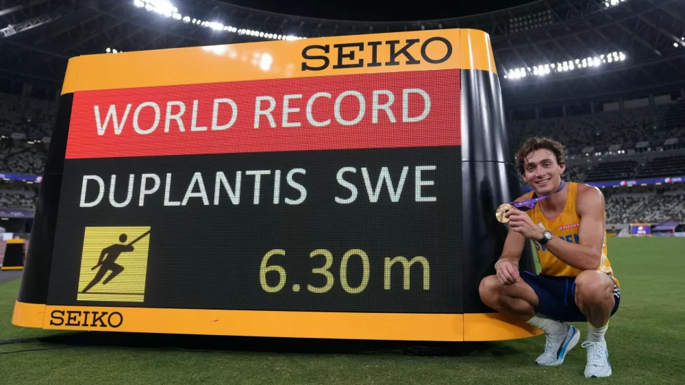 World Athletics Championships Tokyo 2025 - Men's Pole Vault Final - Japan National Stadium, Tokyo, Japan - September 15, 2025 Sweden's Armand Duplantis poses next to the scoreboard as he celebrates with his medal after winning gold and breaking the world record in the final REUTERS/Aleksandra Szmigiel
