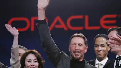 Oracle CEO Larry Ellison, center, smiles with Oracle CFO Safra Catz, left, and Oracle president Charles Phillips, second from right, during the Oracle Open World conference in San Francisco, Wednesday, Oct. 25, 2006. Oracle Corp. is scheduled to report fiscal second-quarter earnings after the bell. (AP Photo/Paul Sakuma)