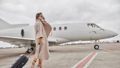 Mature business woman in coat near her jet in airport