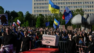A figure with a box painted with a cartoon depicting Slovakian Prime Minister Robert Fico sits at a table covered in red material, representing blood, at an art performance held during an anti-government protest, in Bratislava, Slovakia, May 9, 2025. REUTERS/Radovan Stoklasa